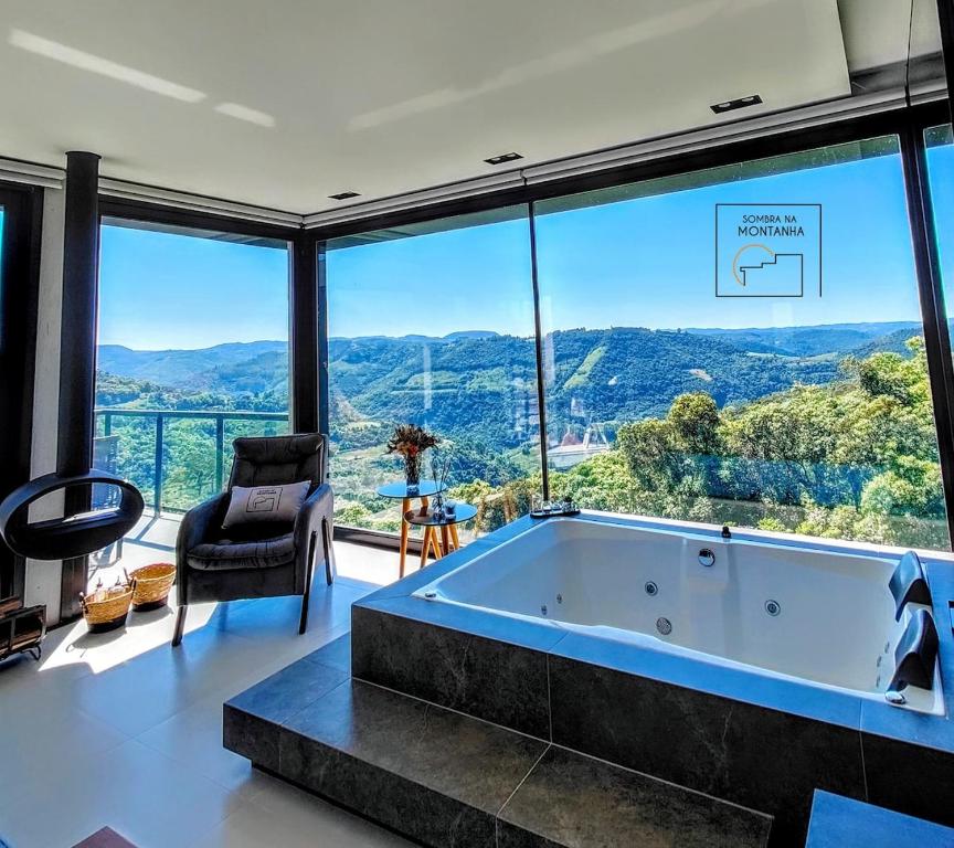 a large tub in a room with large windows at Sombra na Montanha in Nova Petrópolis