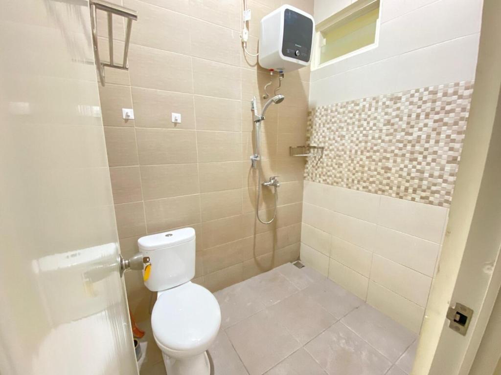 a bathroom with a toilet and a shower at Villa Lisha Orolas in Blimbing