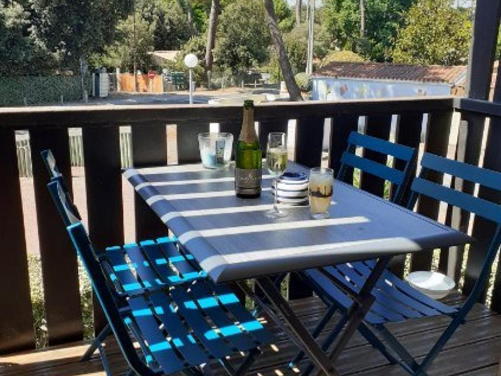 - une table bleue avec 2 chaises et une bouteille de vin dans l'établissement Studio rénové à 150m de la plage avec vélos et animaux acceptés - FR-1-494-199, à Saint-Georges-de-Didonne