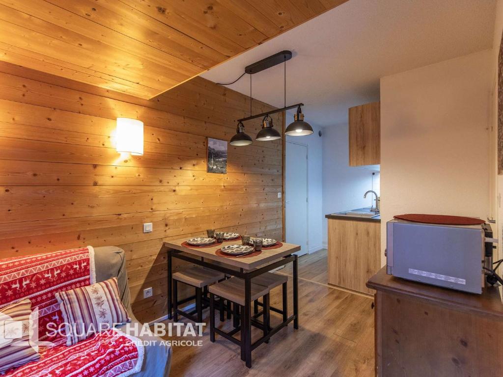 un salon avec une table et une cuisine dans l'établissement Appartement T3 avec terrasse, jardin et piscines à Cauterets - FR-1-401-310, à Cauterets