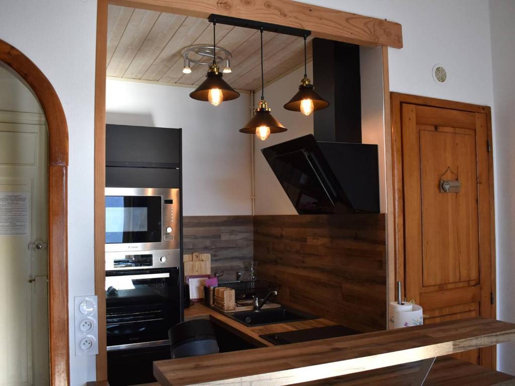 La cuisine est équipée d'un réfrigérateur noir et d'un four micro-ondes. dans l'établissement Studio Charmant à Font-Romeu avec Vue Pyrénées - FR-1-580-128, à Font-Romeu-Odeillo-Via