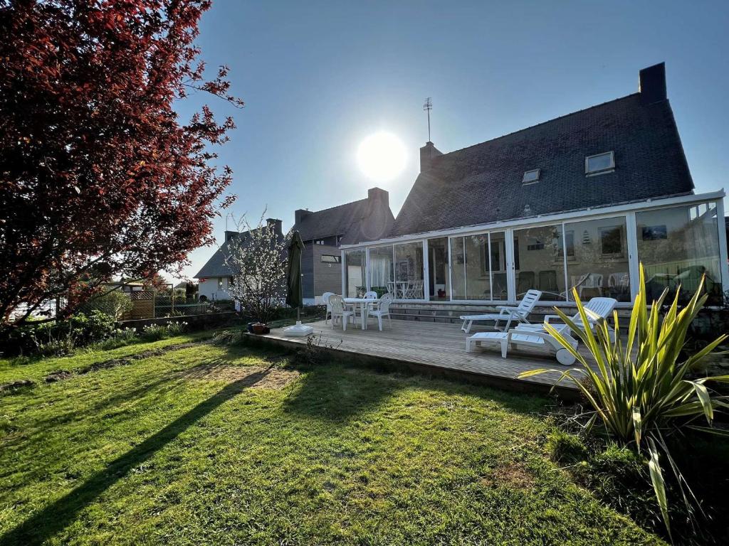 une maison avec une terrasse dotée d'un mobilier blanc. dans l'établissement Maison Port-Louis 4 chambres, accès plage, WIFI, animaux admis - FR-1-479-205, à Port-Louis