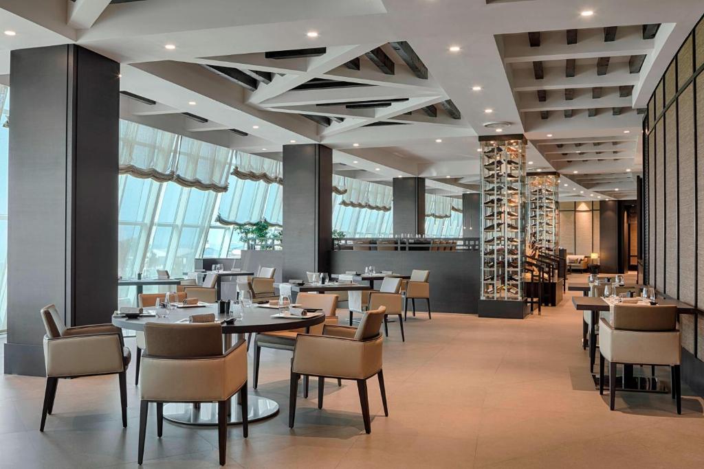 克拉布德品斯Sheraton Club des Pins Resort的有桌椅和窗户的餐厅