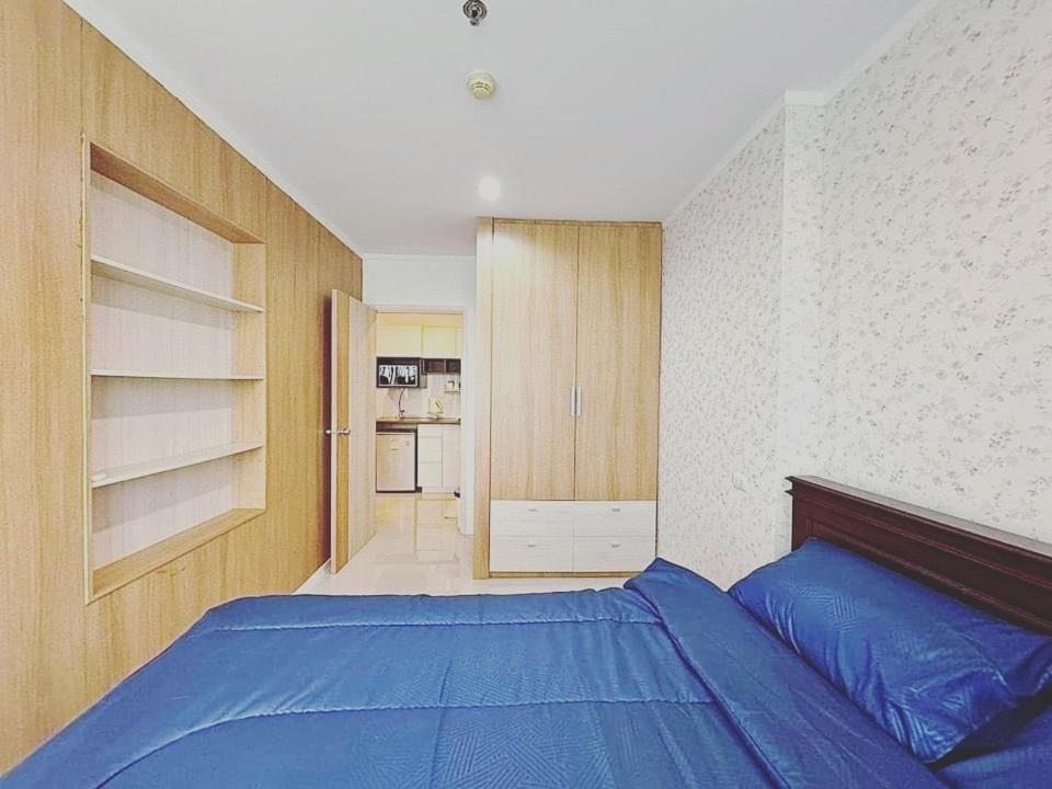a bedroom with a blue bed and a kitchen at Seaview 3rd floor วิวทะเล 1Bedroom 1Bathroom 33Sqm in Jomtien Beach