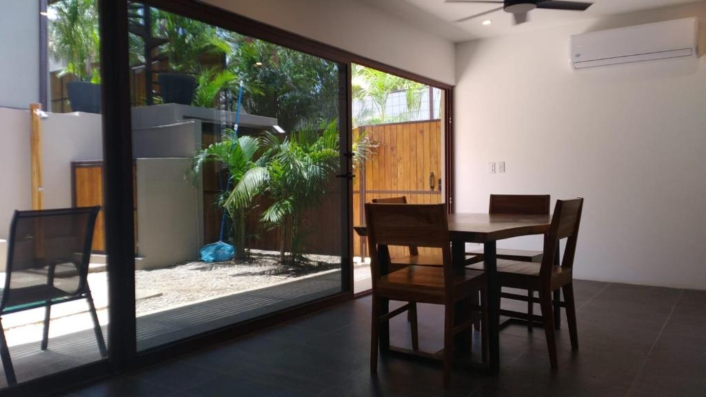 タマリンドにあるGreen Turtle Townhome #1 Private Pool & Garden 300 Mtrs to Beachのダイニングルーム(テーブル、椅子、ガラスのスライドドア付)