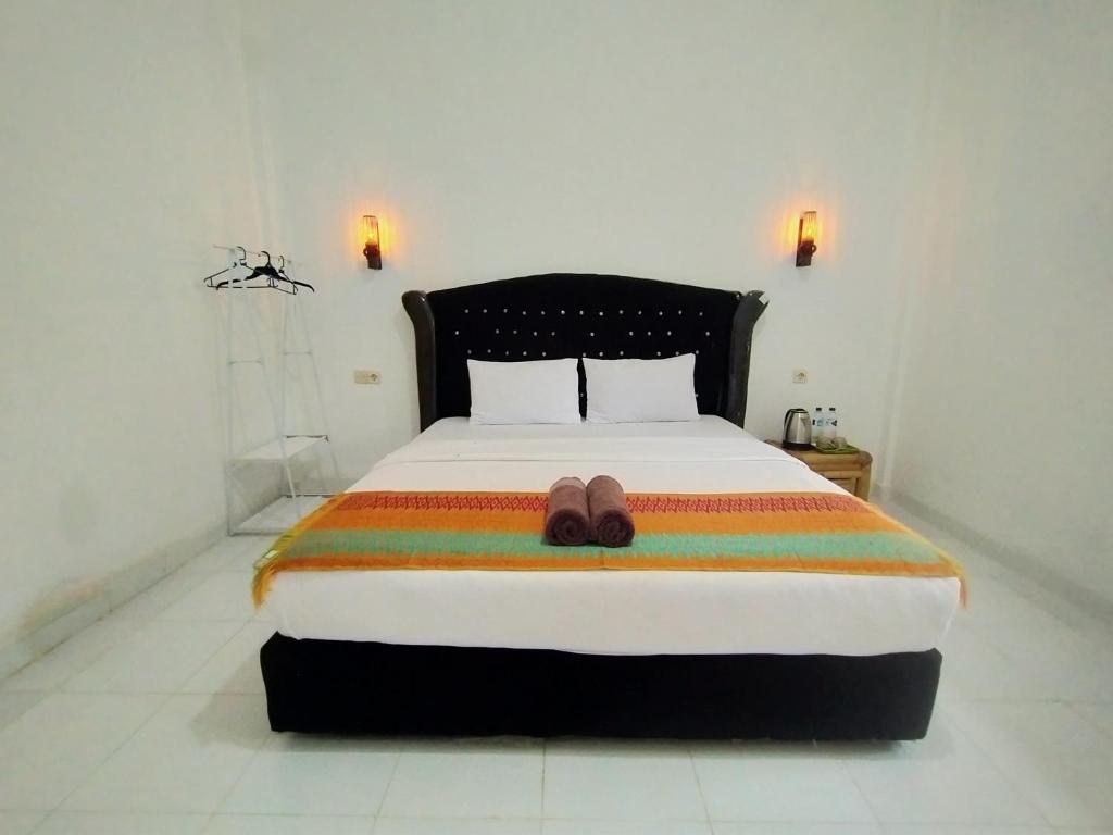 a bed with a pair of shoes sitting on it at Tania Homestay in Bumbang