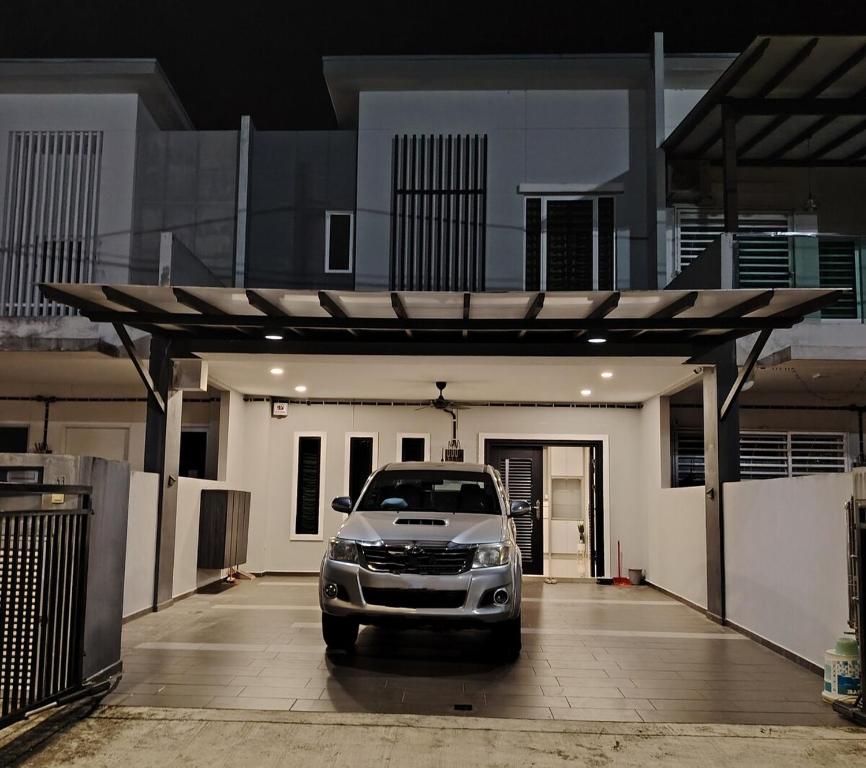 un coche aparcado en un estacionamiento frente a una casa en dotMy Homestay Kluang 15 pax - NETFLIX - WiFi - Autogate - 4 Rooms - 4 Bathrooms, en Keluang