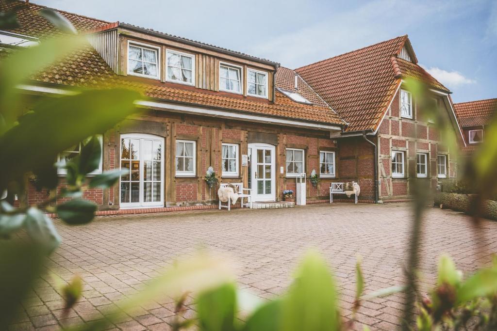 ein großes Backsteinhaus mit einem Hund davor in der Unterkunft Hotel Auszeit in Isernhagen