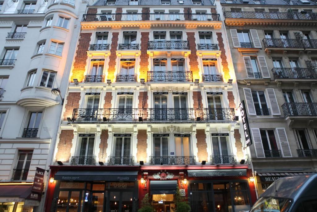 un grand bâtiment avec balcon dans une rue de la ville dans l'établissement Hotel Celtic, à Paris