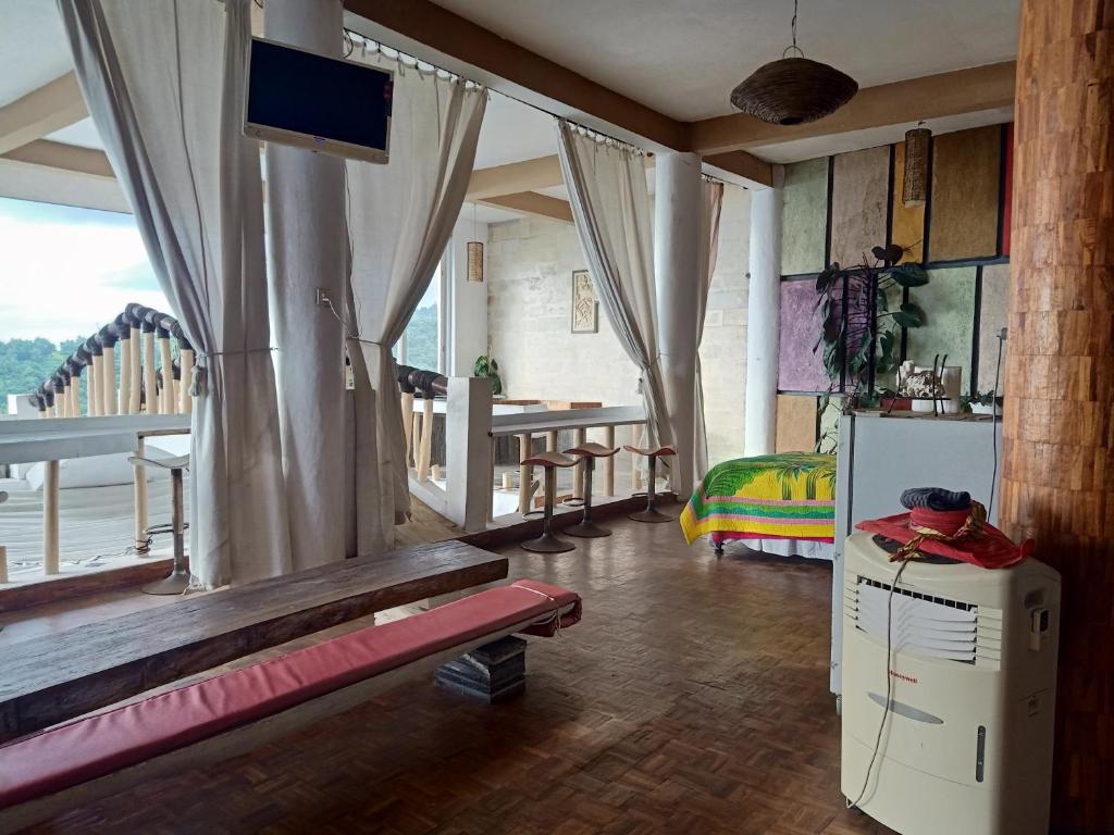 a room with a bed and a television and a table at Rara Villas Lombok in Senggigi 