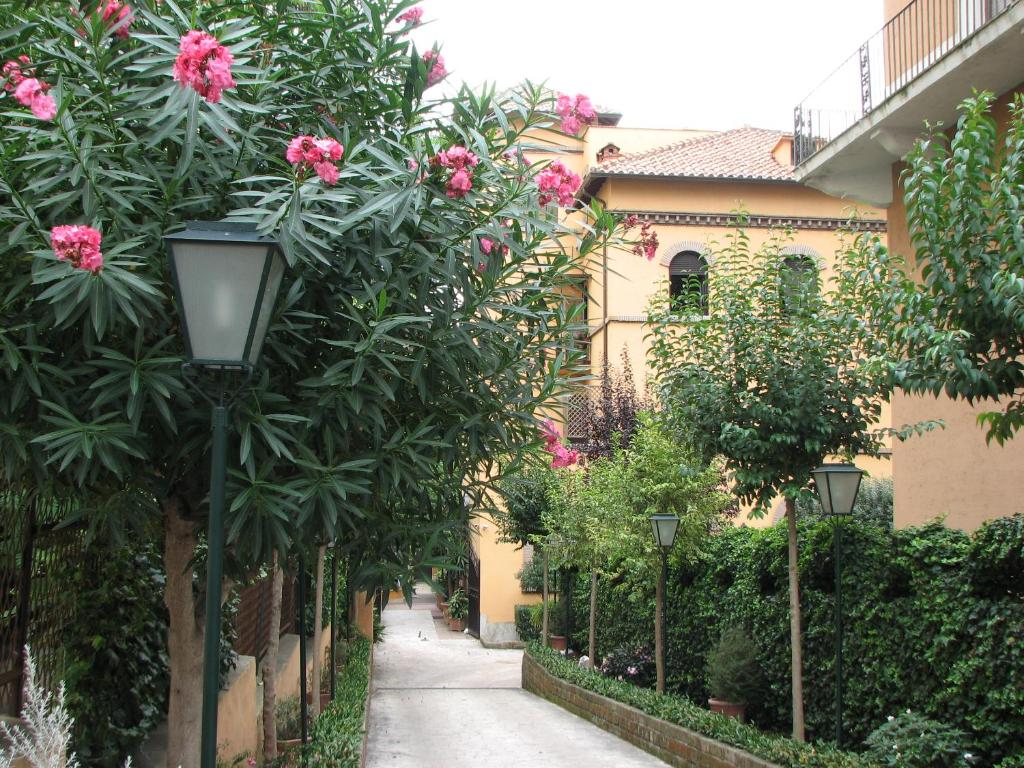 un callejón con flores rosas y luz de la calle en Villa Matissa, en Roma