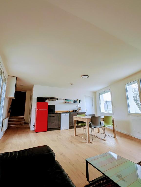 un salon avec une table et une cuisine dans l'établissement Appartement 2 chambres 4 personnes, à Sainte-Reine-de-Bretagne