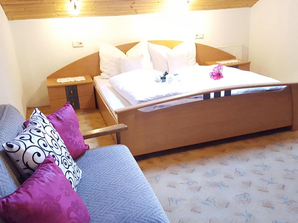 um quarto de hotel com duas camas e um sofá em Hackeihof em Achenkirch
