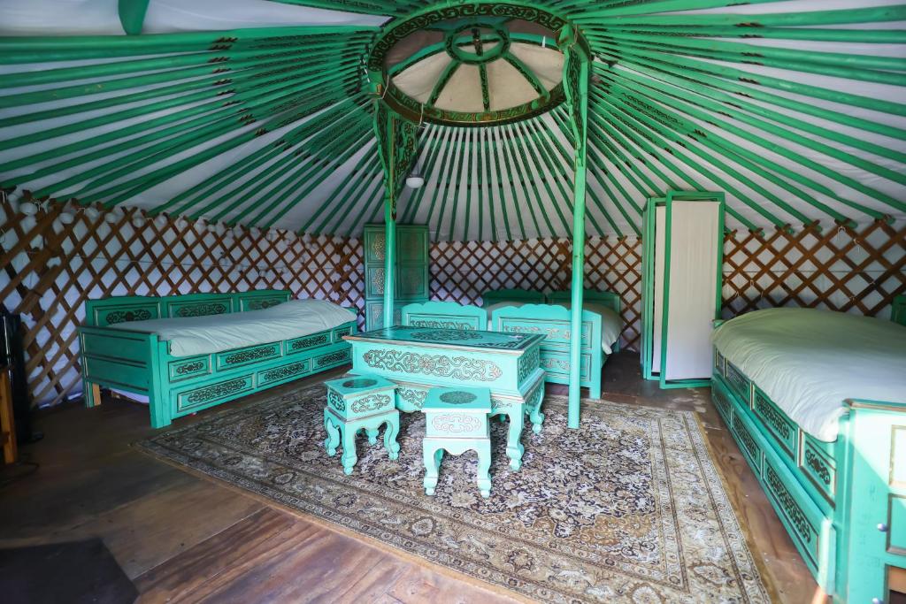 a room with blue beds and tables in a yurt at Yourtes Olachat proche Annecy in Faverges