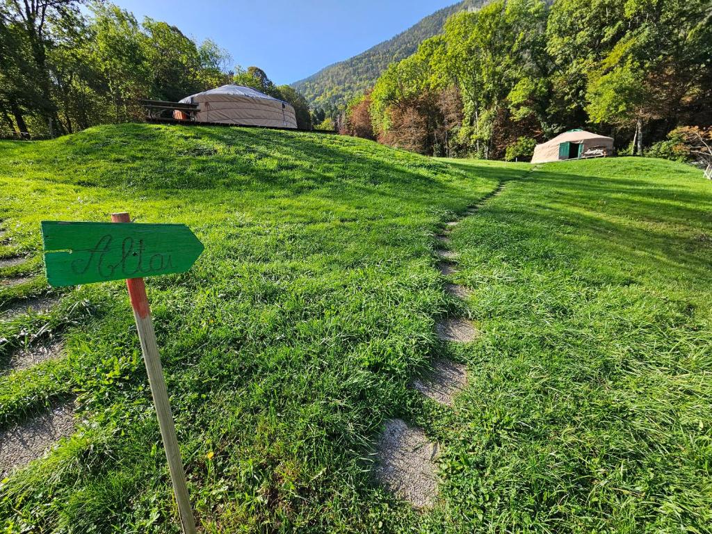 a green sign in the middle of a field at Yourtes Olachat proche Annecy in Faverges