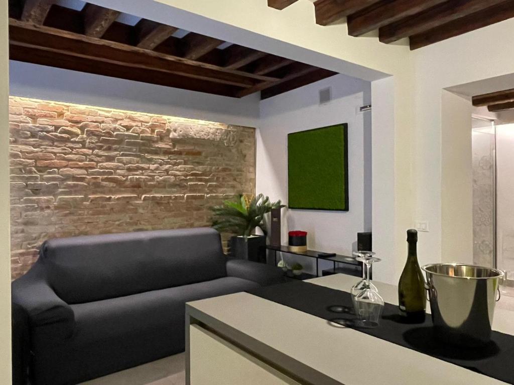 Hotel VENICELOFT 5minutefromRialto 10minutefromSanMarco 5minitestationTrain infrontofCaD'ORO, a living room with a couch and a brick wall at VENICELOFT 5minutefromRialto 10minutefromSanMarco 5minitestationTrain infrontofCaD'ORO in Venice