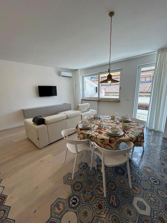 un soggiorno con tavolo, sedie e divano di Isabel Apartment ad Ancona