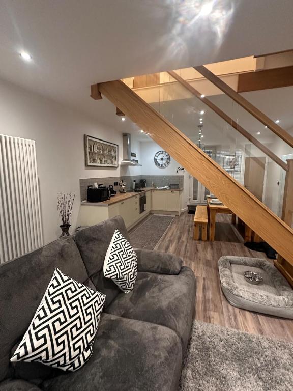 a living room with a couch and a kitchen at Abbys Cottage in Windermere
