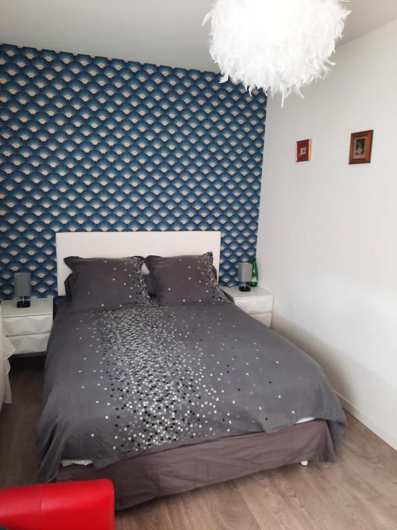 - une chambre avec un lit et un mur bleu et blanc dans l'établissement La conviviale, à Bénouville