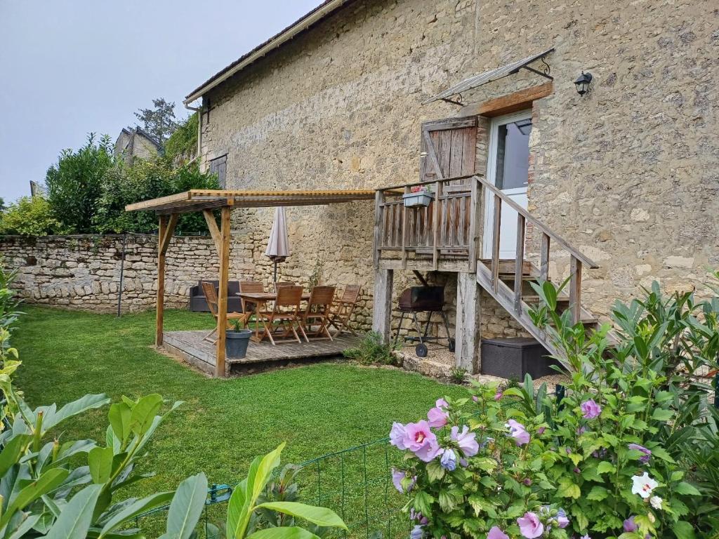 a house with a deck and a table and chairs at La maison du colombophile in Neuville-sur-Ailette