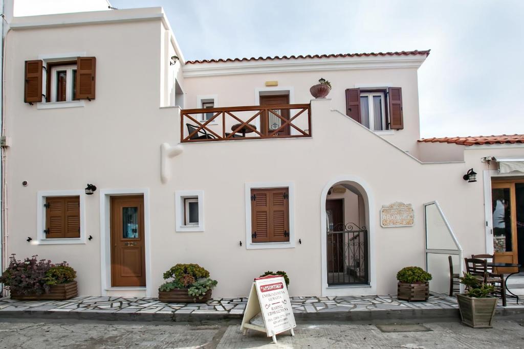 una casa blanca con un cartel delante en Arxontiko, en Tinos