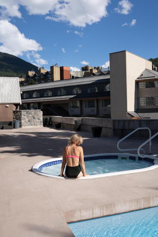 a woman in a bikini sitting in a small pool at Adara Hotel in Whistler