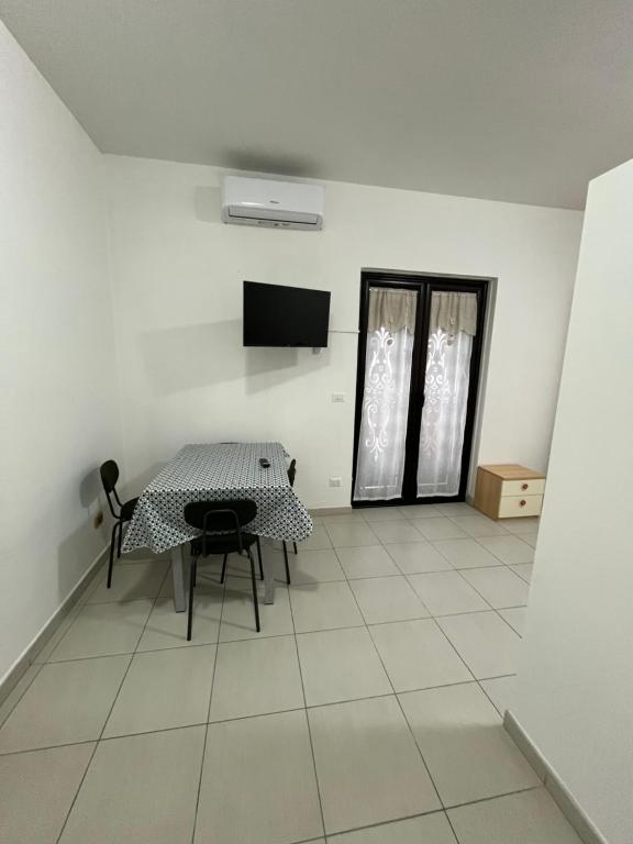a dining room with a table and a tv on the wall at Aurora Rooms in Pomigliano dʼArco