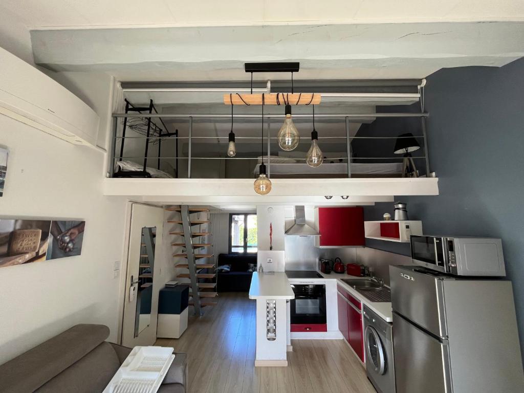 - une petite cuisine avec des placards rouges et blancs dans la chambre dans l'établissement Le chant des Cigales STUDIO Duplex climatisé près des plages, à Sausset-les-Pins