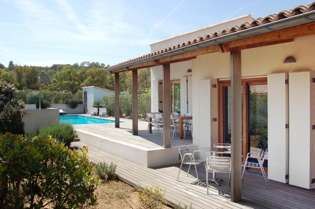 a house with a deck and a swimming pool at Villa Coucou Les Amis in Sainte-Lucie de Porto-Vecchio