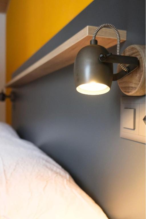 a light on a wall next to a bed at Eiger Lodge Easy in Grindelwald