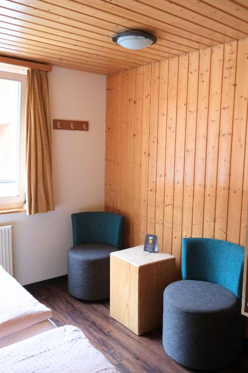 two chairs and a table in a room at Eiger Lodge Easy in Grindelwald
