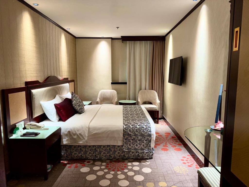 Postel nebo postele na pokoji v ubytování Macau Masters Hotel