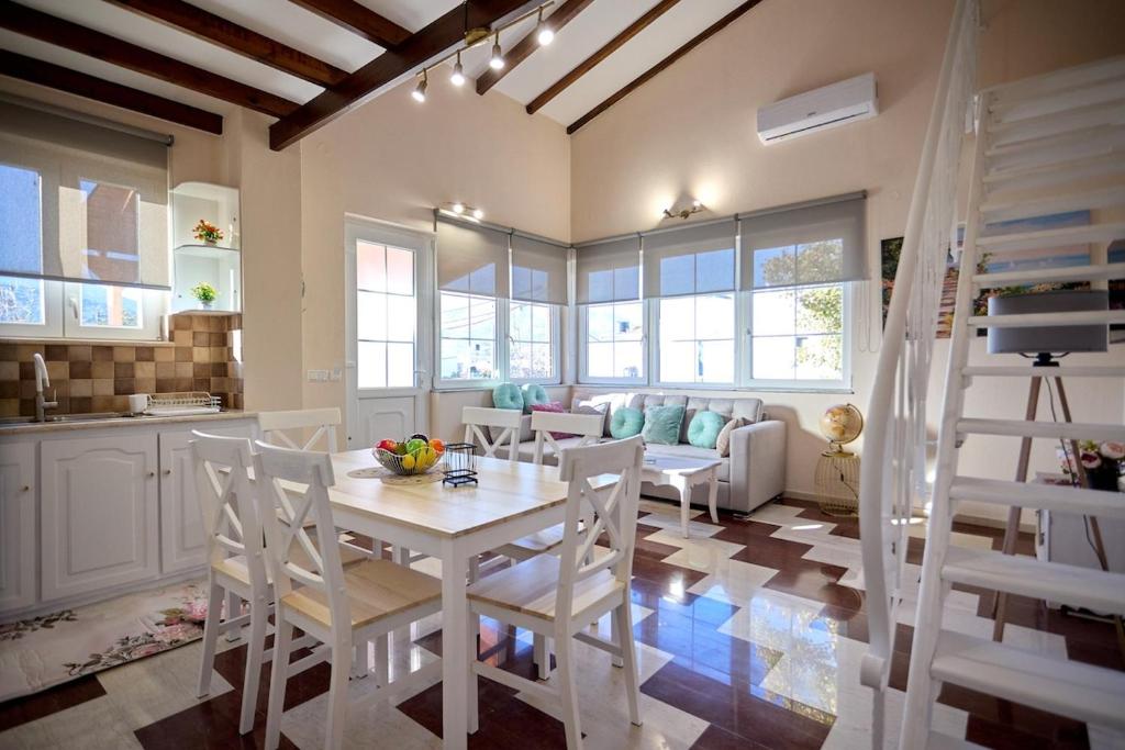 una cucina e un soggiorno con tavolo e sedie di Sweet Cottage In The City a Chio (Chios)