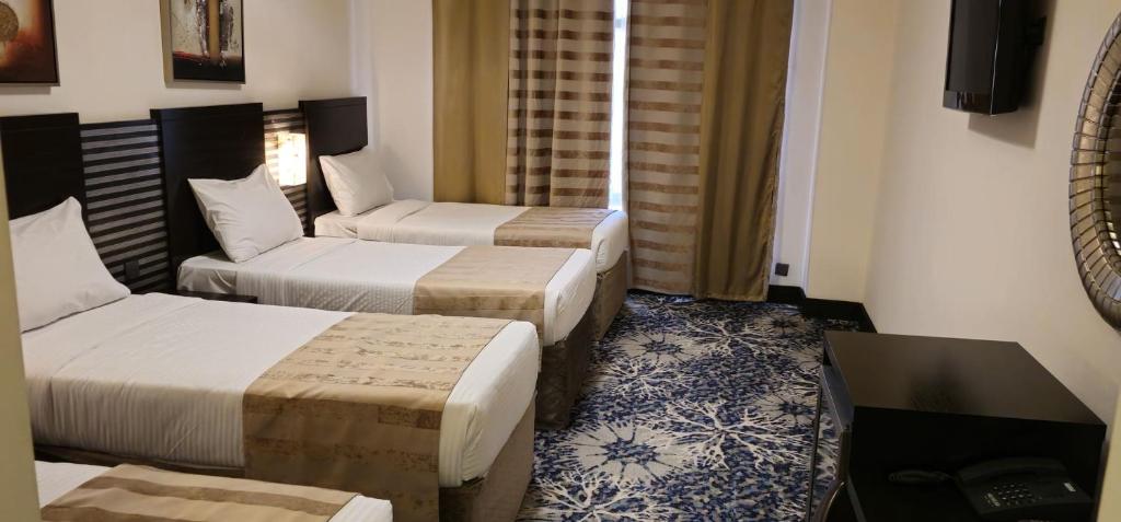 Postel nebo postele na pokoji v ubytování Al Hidayah Towers Hotel