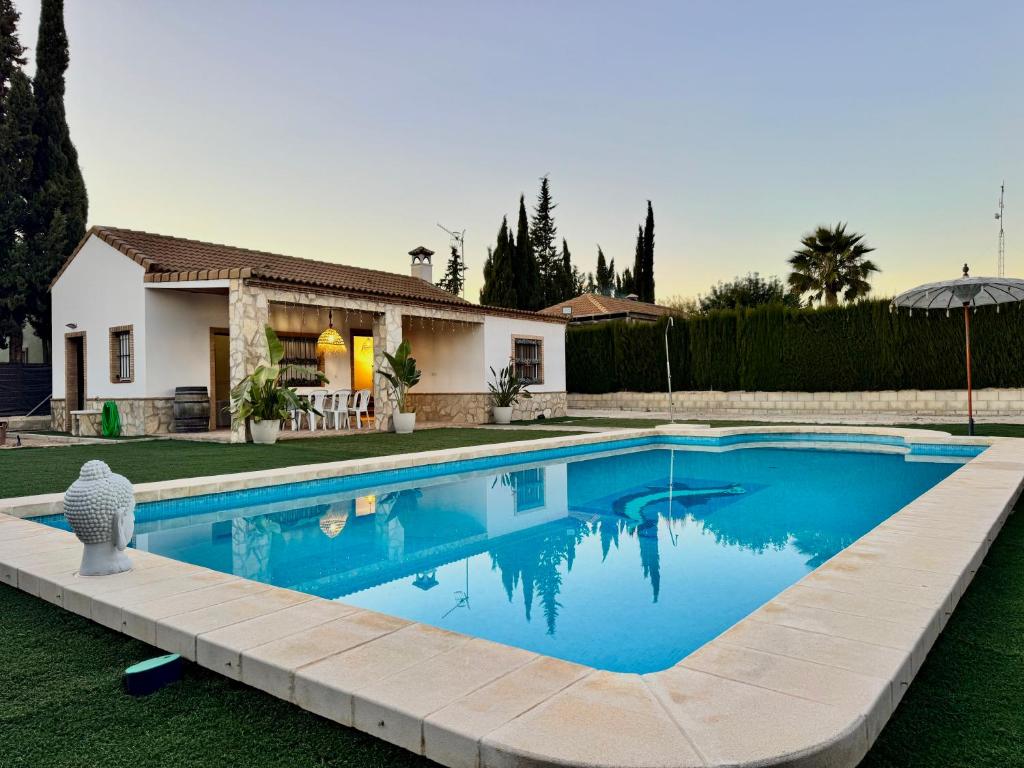a swimming pool in front of a house at Can Pines in Paradas