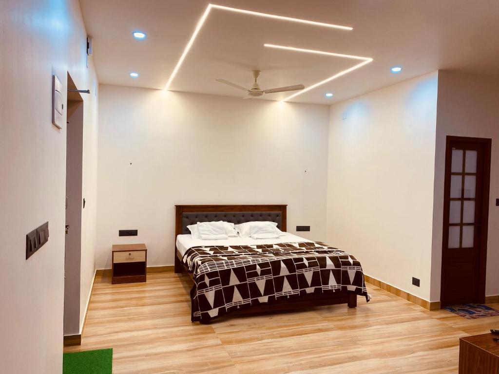 a bedroom with a bed in a white room at The oro homestay in Ullāl