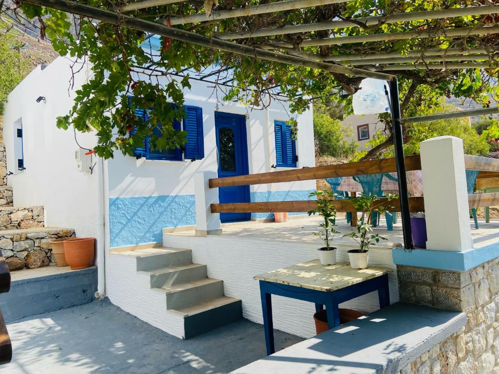 a patio with stairs and a table and blue doors at Emborios Views - Studio in Emborios