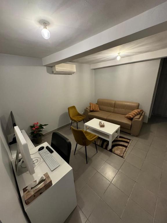 - un salon avec un canapé et un bureau avec un ordinateur dans l'établissement Quiet self-catering apartment, à Aubervilliers