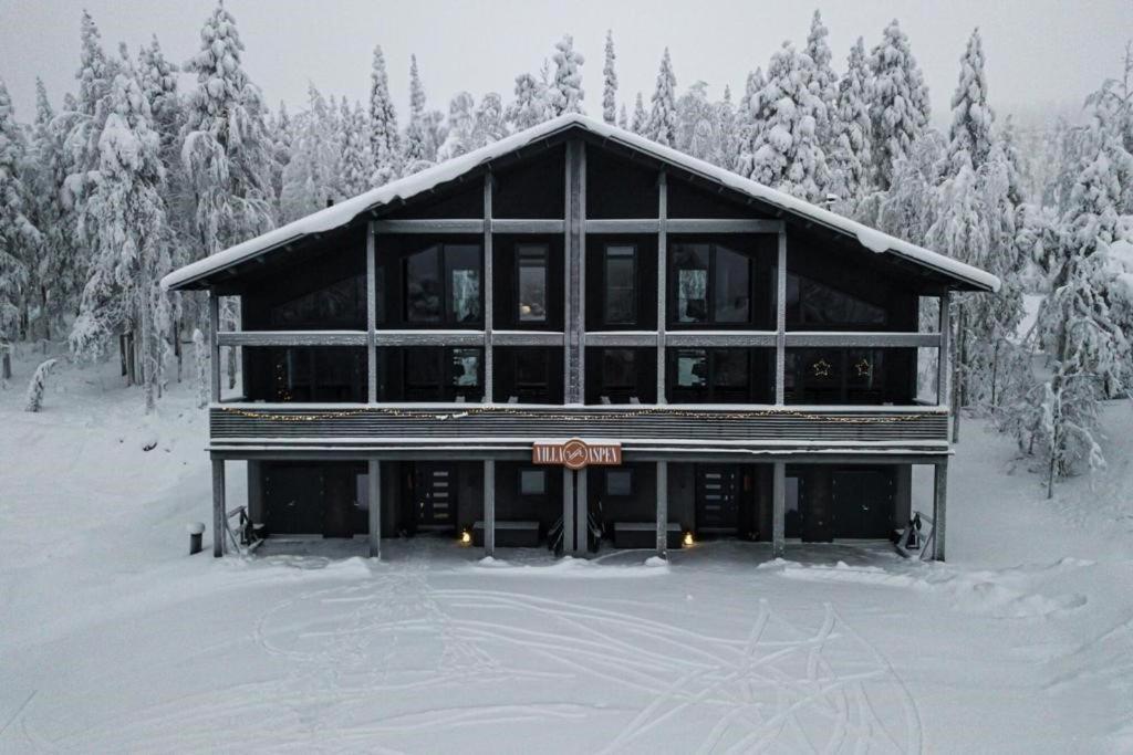 een groot gebouw in de sneeuw met sneeuw bedekte bomen bij Villa Aspen D Ski-in Ski-out by Aavalevi in Levi
