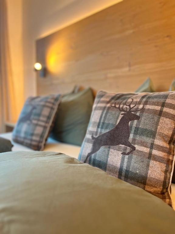 a bed with two pillows with a deer on them at Ciasa Valiares in San Vigilio Di Marebbe