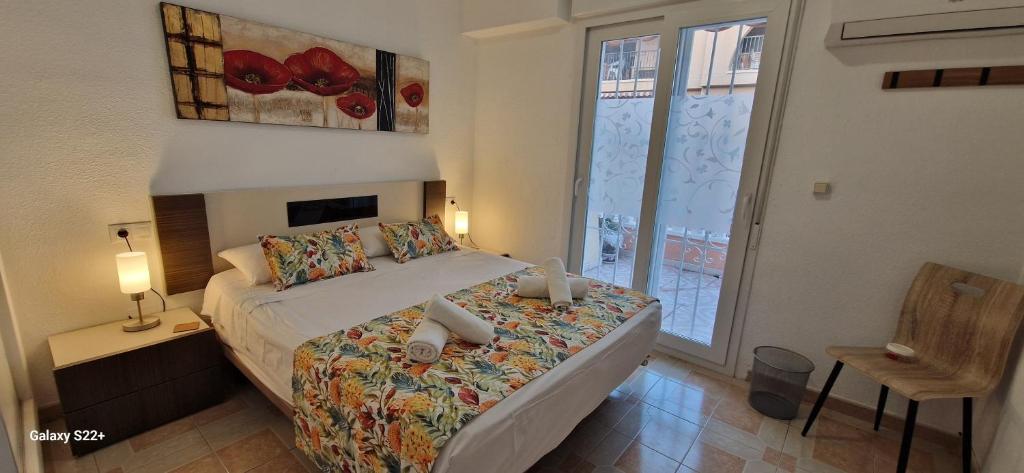 Un dormitorio con una cama en una habitación con ventana. en Casa Paseo, en Torrevieja