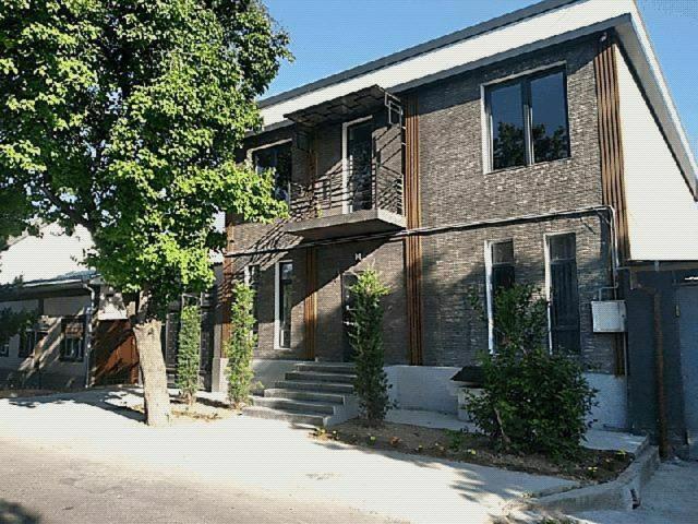 een stenen huis met een trap en een balkon bij Дом хай-тек in Toshkent-Passajir Bekati