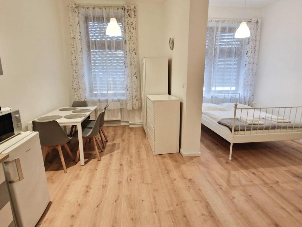 Kleines Zimmer mit einem Schlafzimmer, einem Tisch und einem Bett. in der Unterkunft Green Apartment Studio L30 Neukölln in Berlin
