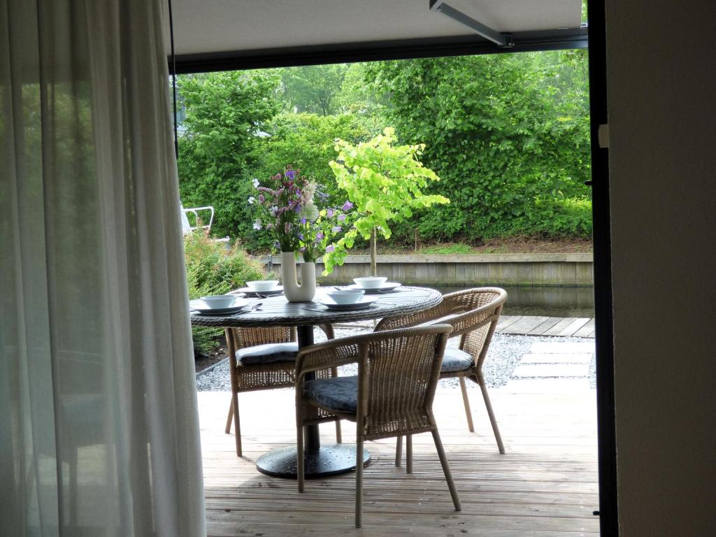 a table with chairs and a vase of flowers on a patio at Immer simmer in Lemmer