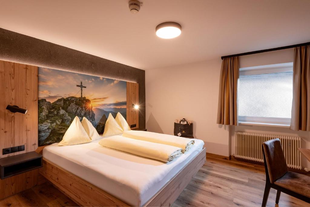 Postel nebo postele na pokoji v ubytování Das Sonnleiten Ski- und Motorradhotel Bruck im Zillertal