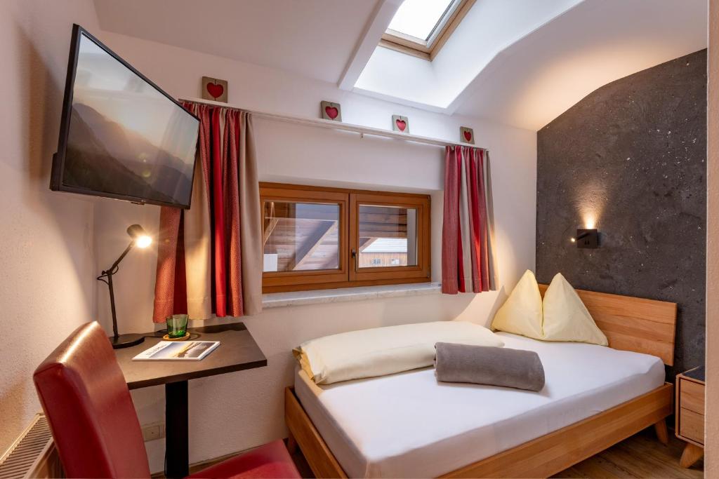 Postel nebo postele na pokoji v ubytování Das Sonnleiten Ski- und Motorradhotel Bruck im Zillertal