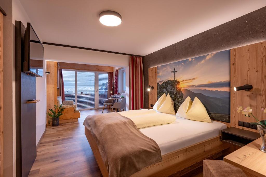 Postel nebo postele na pokoji v ubytování Das Sonnleiten Ski- und Motorradhotel Bruck im Zillertal