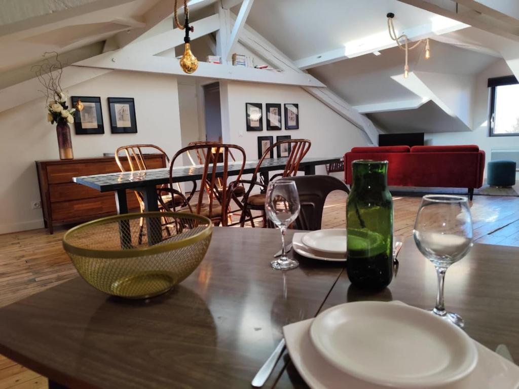a wooden table with two glasses and a bottle of wine at le marais in Romans-sur-Isère