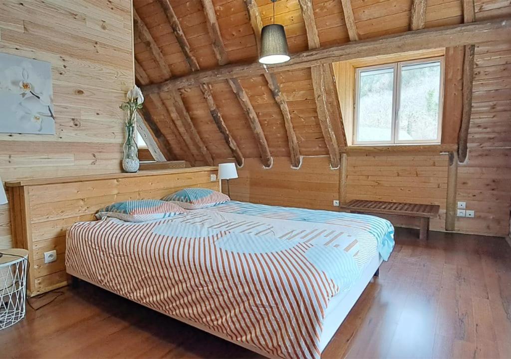 a bedroom with a bed in a wooden cabin at Le Nid Montagnard in Aucun