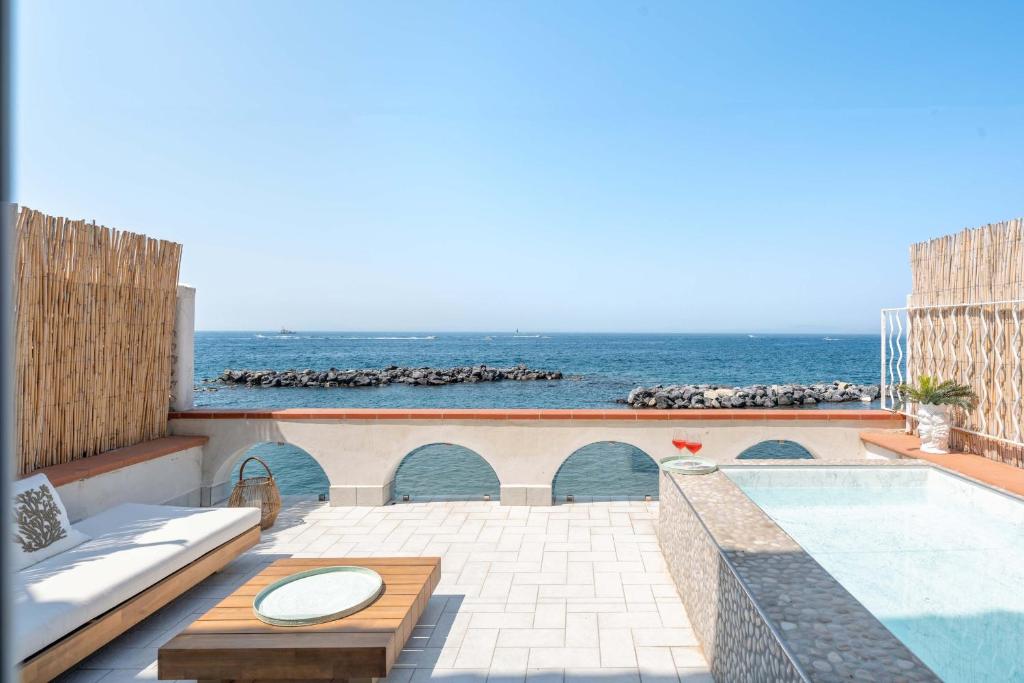 a patio with a swimming pool and the ocean at AMORE RENTALS - Villa Marti in Massa Lubrense